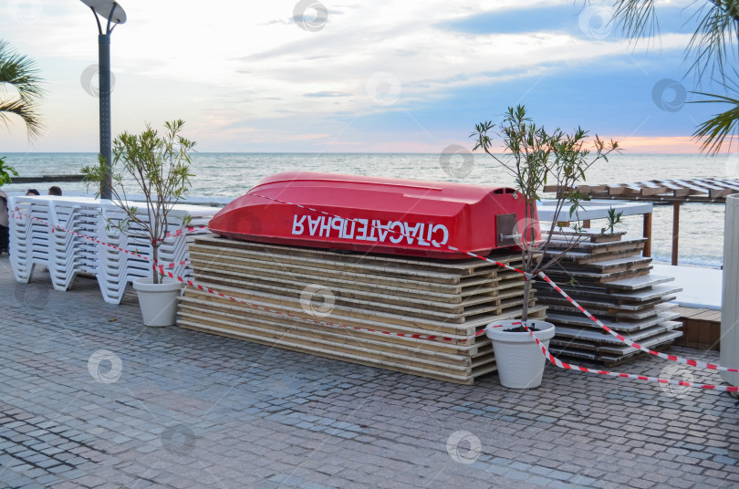 Скачать Россия, Краснодарский край, Сочи. Ноябрь 2024. Убранный пляжный инвентарь. Спасательная лодка фотосток Ozero