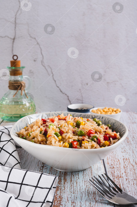 Скачать Домашний жареный рис с горошком, кукурузой и перцем в миске на столе в вертикальном положении фотосток Ozero