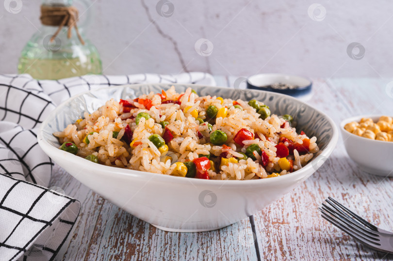 Скачать Домашний жареный рис с горошком, кукурузой и перцем в миске на столе фотосток Ozero