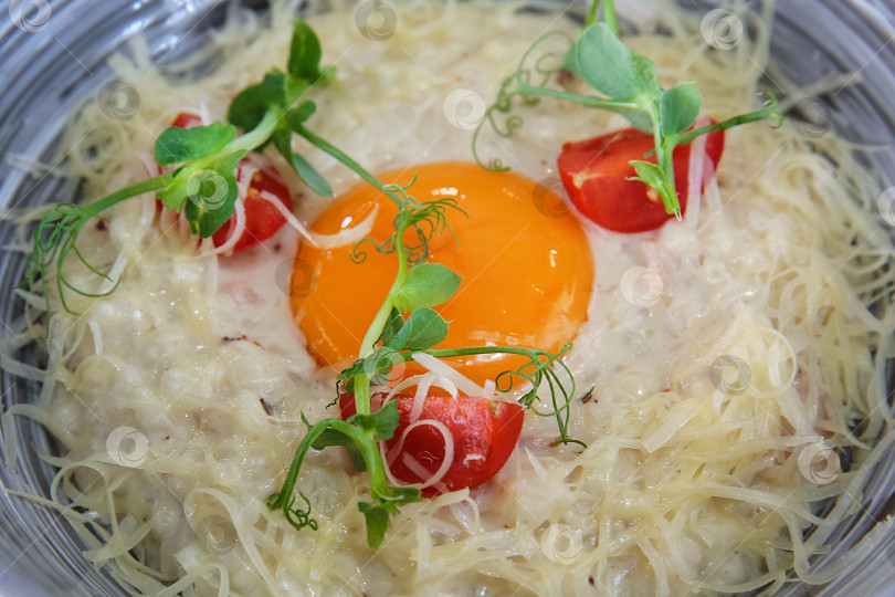 Скачать Паста с сыром, яичницей-глазуньей, помидорами и зеленью на тарелке фотосток Ozero