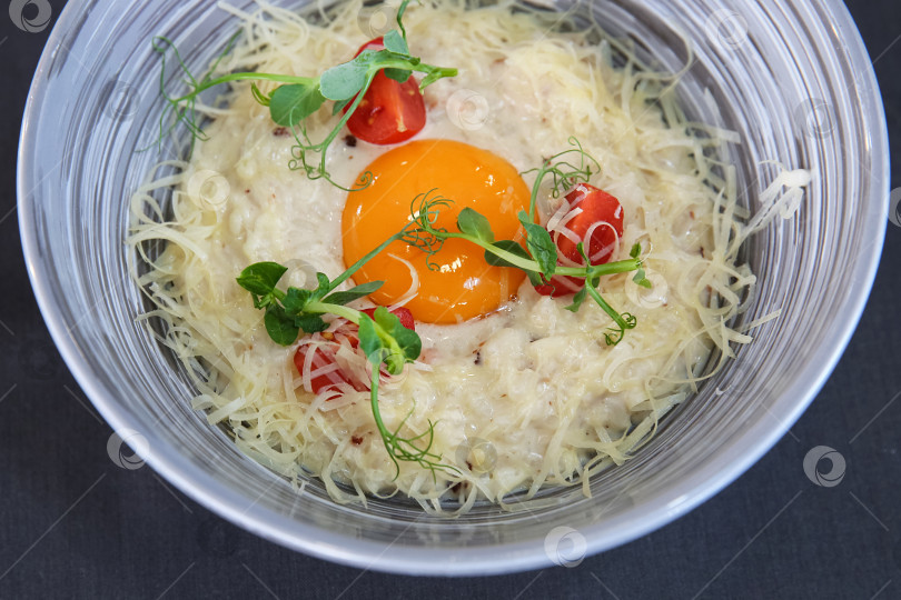 Скачать Паста с сыром, яичницей-глазуньей, помидорами и зеленью на тарелке фотосток Ozero