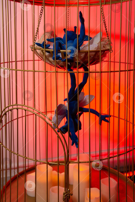 Скачать Сюрреалистические голубые существа в клетке со свечами. фотосток Ozero