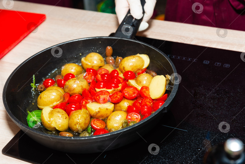 Скачать Обжаренный молодой картофель с помидорами черри.  фотосток Ozero