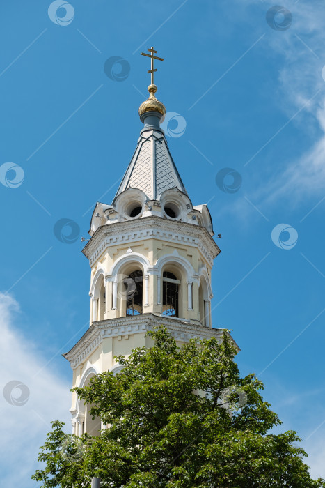 Скачать Колокольня, увенчанная золотым крестом, на фоне ясного голубого неба в безмятежном городском пейзаже при дневном свете - Ставрополь, Россия, 1 июня 2025 года фотосток Ozero