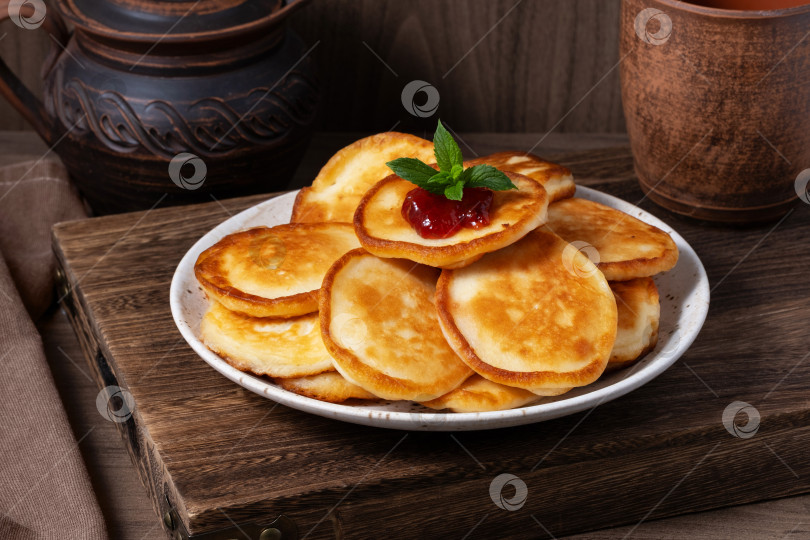 Скачать Вкусные золотистые блинчики с вареньем на деревянном столе фотосток Ozero