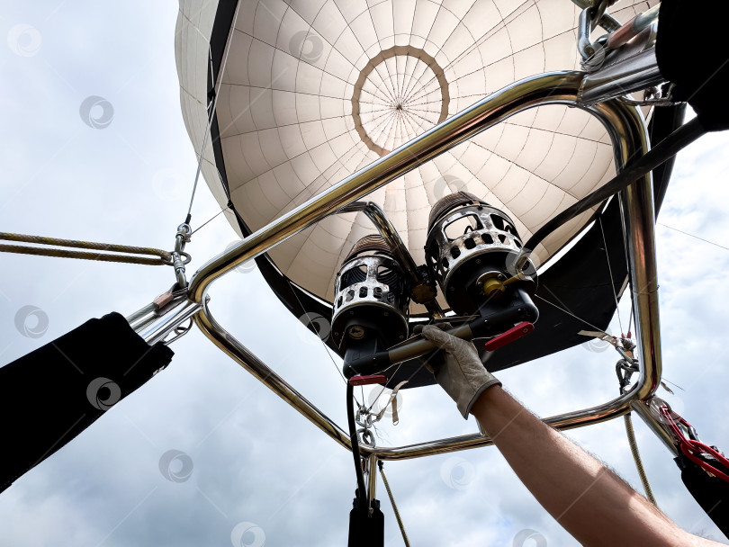 Скачать Подготовка к запуску воздушного шара с регулировкой горелок рукой в перчатке фотосток Ozero