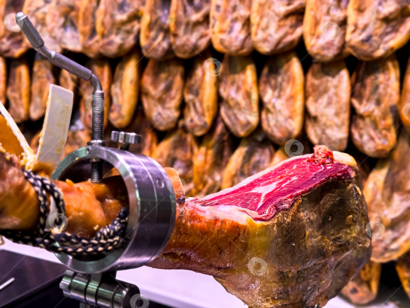 Скачать Витрина с ветчиной Серрано и мясной нарезкой в традиционной рыночной обстановке фотосток Ozero