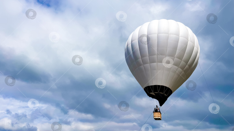 Скачать Белый воздушный шар на фоне облачного неба в живописной приключенческой сцене на открытом воздухе фотосток Ozero