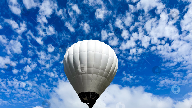 Скачать Белый воздушный шар на фоне ярко-голубого неба с пушистыми облаками фотосток Ozero
