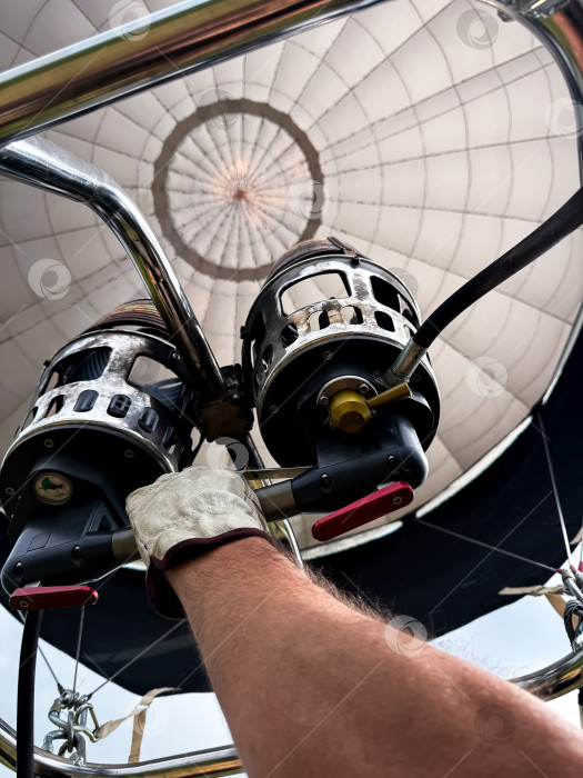 Скачать Крупный план горелки на воздушном шаре с кавказским мужчиной, управляющим рукой фотосток Ozero