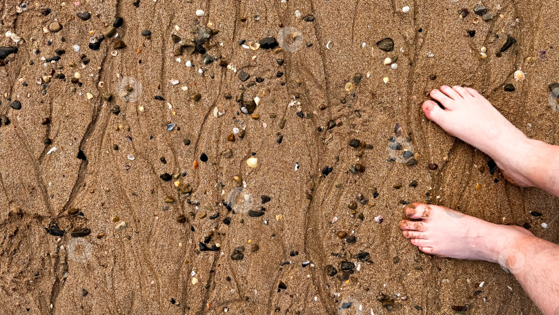 Скачать Босые ноги на песчаном пляже с ракушками и галькой фотосток Ozero