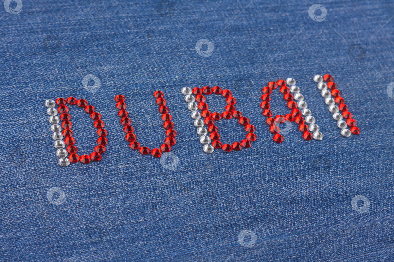 Скачать Надпись Dubai крупным планом, инкрустированная стразами на джинсовой ткани. фотосток Ozero