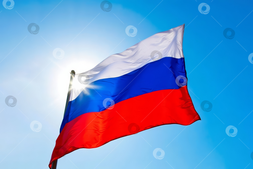 Скачать развевающийся российский флаг на фоне яркого голубого неба фотосток Ozero