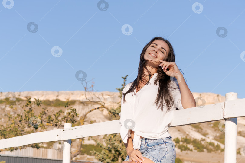 Скачать Женщина стоит на заборе и улыбается фотосток Ozero