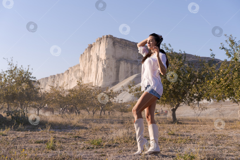 Скачать Женщина стоит в поле на фоне горы. фотосток Ozero