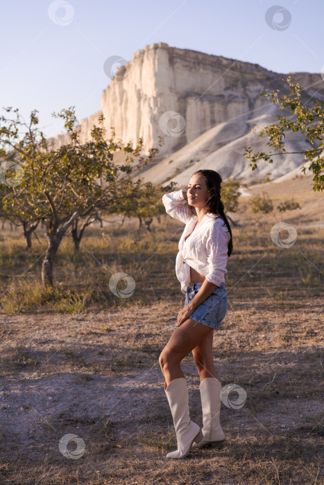 Скачать Женщина стоит в пустыне в белой рубашке и синих шортах фотосток Ozero