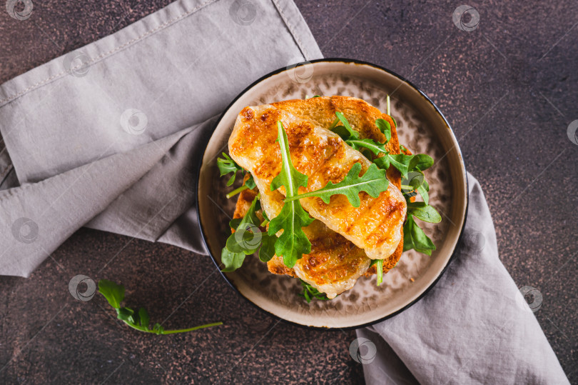 Скачать Крупный план вкусного сэндвича с жареным халлуми и рукколой на тарелке на столе вид сверху фотосток Ozero