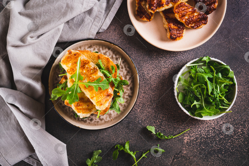 Скачать Вкусный сэндвич с жареным халлуми и рукколой на тарелке на столе вид сверху фотосток Ozero