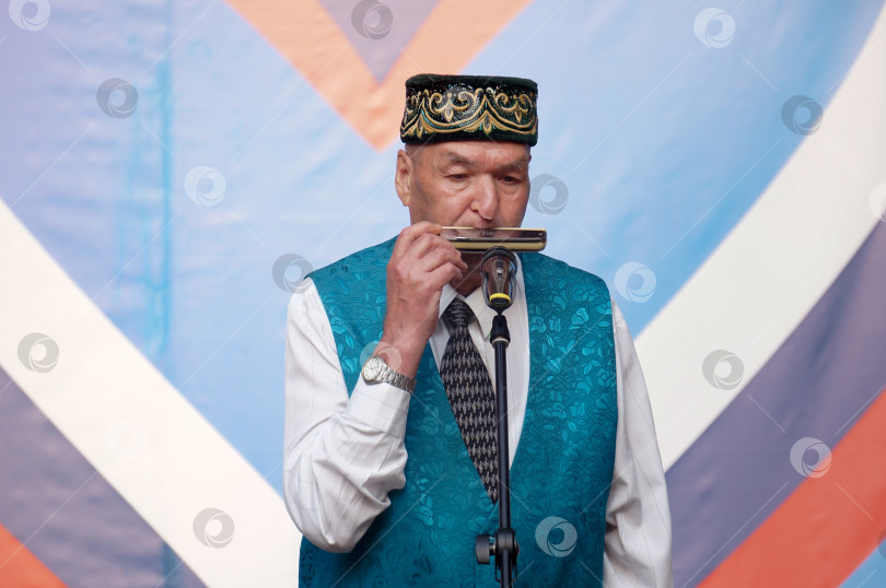 Скачать Казань, Татарстан, Россия – 11 июня 2025: соло на губной гармошке с татарскими  мелодиями фотосток Ozero