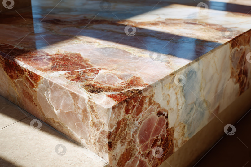 Скачать Крупный план полированной мраморной поверхности с замысловатыми узорами и насыщенными цветами, освещенной естественным светом, подчеркивает красоту мастерства обработки камня и элементов дизайна. фотосток Ozero