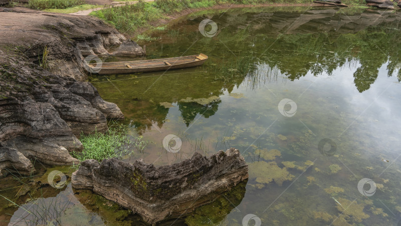 Скачать К берегу озера пришвартована старая некрашеная деревянная лодка. фотосток Ozero