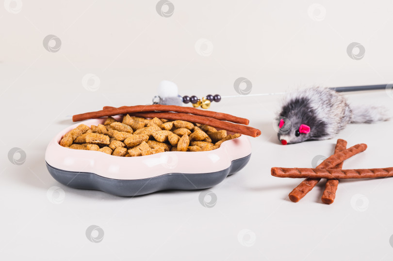 Скачать Миска с кошачьим кормом, лакомствами и игрушками на столе фотосток Ozero