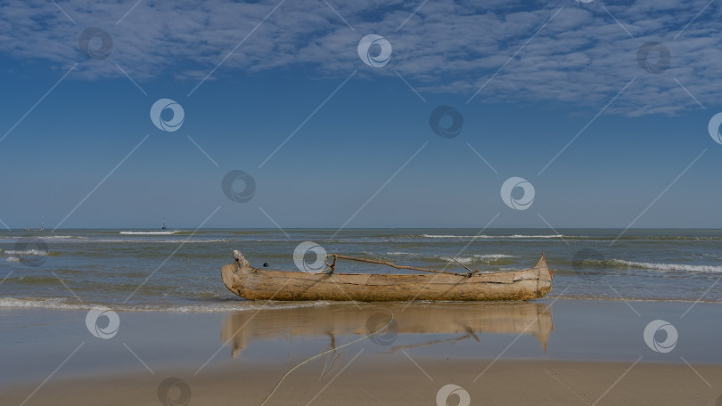 Скачать Отлив в океане. Старая некрашеная лодка-пирога на мелководье. фотосток Ozero
