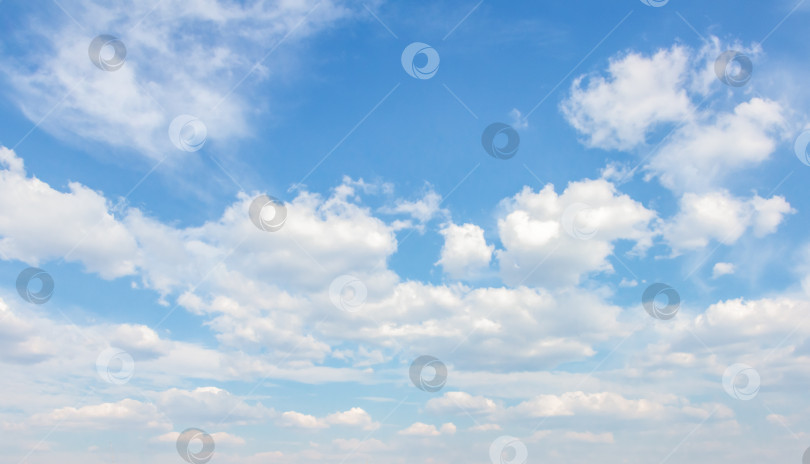 Скачать Бескрайнее голубое небо с пушистыми белыми облаками, разбросанными по горизонту, создают безмятежную атмосферу, идеально подходящую для создания фона и проектов на природную тематику. фотосток Ozero