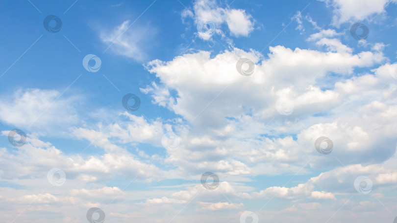 Скачать Бескрайнее голубое небо, наполненное пушистыми белыми облаками, создает безмятежную атмосферу, идеально подходящую для создания фона или дизайнерских проектов с использованием природных элементов и спокойствия. фотосток Ozero