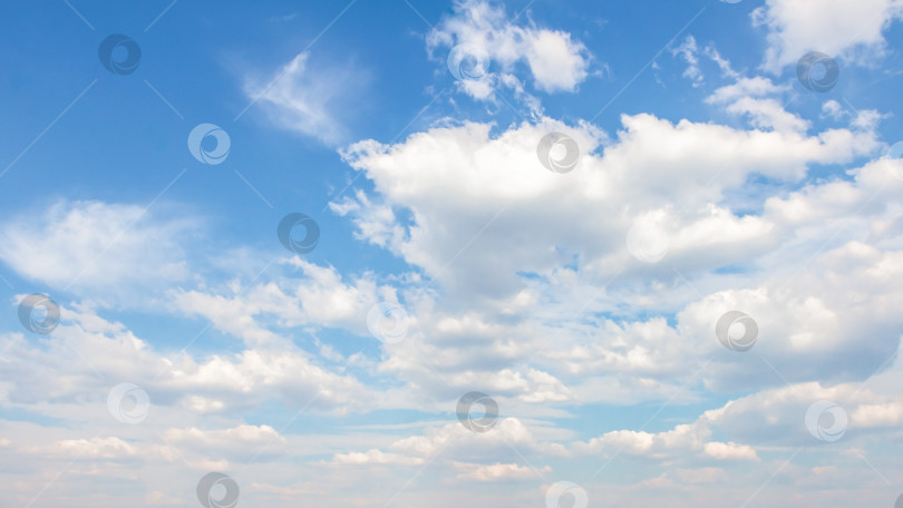 Скачать Обширное голубое небо, наполненное пушистыми белыми облаками, создает безмятежную атмосферу, идеально подходящую для создания фона или дизайнерских проектов с пространством для копирования текста. фотосток Ozero