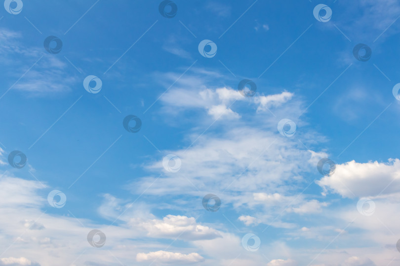 Скачать Обширное голубое небо с пушистыми белыми облаками, создающее безмятежную атмосферу и яркий дневной свет, идеально подходит для создания фона или проектов на природную тематику с пространством для копирования фотосток Ozero
