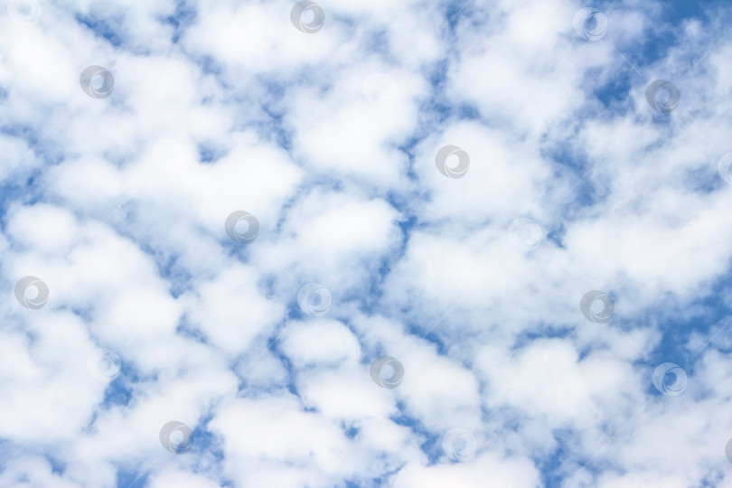 Скачать Обширное голубое небо, наполненное пушистыми белыми облаками, создает безмятежную атмосферу, идеально подходящую для создания фона или дизайнерских проектов с пространством для копирования текста. фотосток Ozero