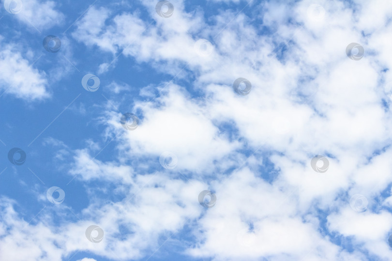Скачать Ярко-голубое небо, наполненное пушистыми белыми облаками, создает безмятежную атмосферу, идеально подходящую для создания фона или дизайна на природную тематику с достаточным пространством для наложения текста. фотосток Ozero