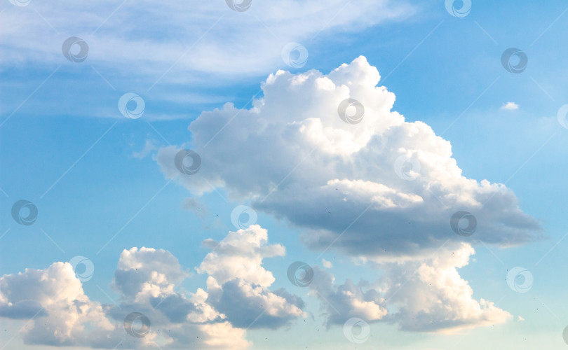 Скачать Пушистые белые облака, разбросанные по ярко-голубому небу, создают безмятежную атмосферу, а мягкий солнечный свет освещает облачные образования и усиливает умиротворяющую картину фотосток Ozero