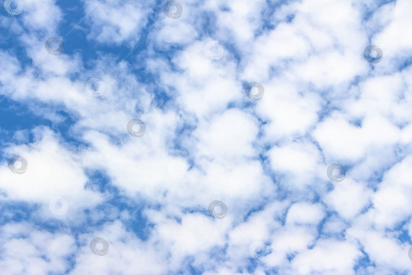 Скачать Обширное голубое небо, наполненное пушистыми белыми облаками, создает безмятежную атмосферу, идеально подходящую для создания фона, дизайна или иллюстрации мирных природных сцен с помощью copy space фотосток Ozero