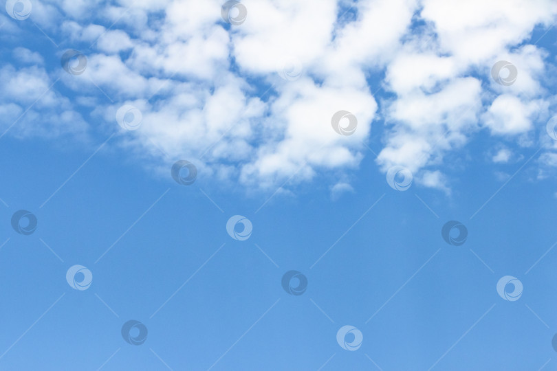 Скачать Бескрайнее голубое небо с разбросанными по нему пушистыми белыми облаками создает безмятежную атмосферу, идеально подходящую для создания фона или проектов на природную тематику. фотосток Ozero