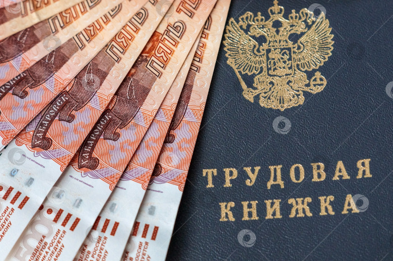 Скачать Саратов, Россия - 19 июня 2025 года. Трудовая книжка и российские пятитысячные банкноты фотосток Ozero