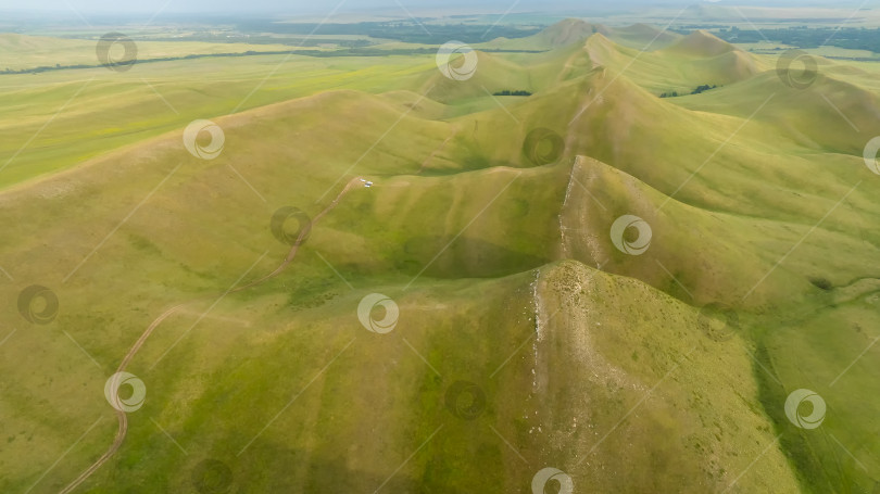 Скачать Зеленая холмистая местность ярким солнечным утром. фотосток Ozero