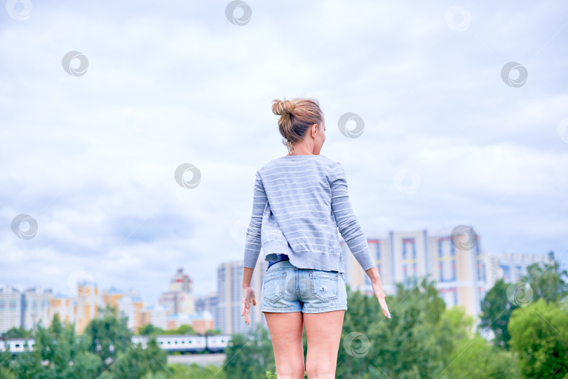 Скачать Девушка стоит на фоне облачного неба. фотосток Ozero