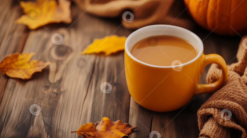 Скачать Уютная осенняя кофейная чашка с разноцветными листьями и тыквой на деревянном столе в теплом освещении фотосток Ozero