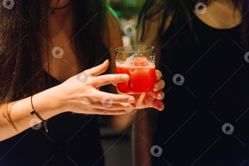 Скачать Женщина с красным коктейлем в руках на вечеринке.  фотосток Ozero
