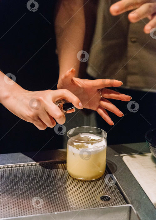 Скачать Бармен распыляет Ароматизатор на коктейль Whiskey Sour.  фотосток Ozero