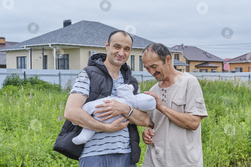 Скачать Три поколения семьи на свежем воздухе: дедушка, отец и ребенок фотосток Ozero