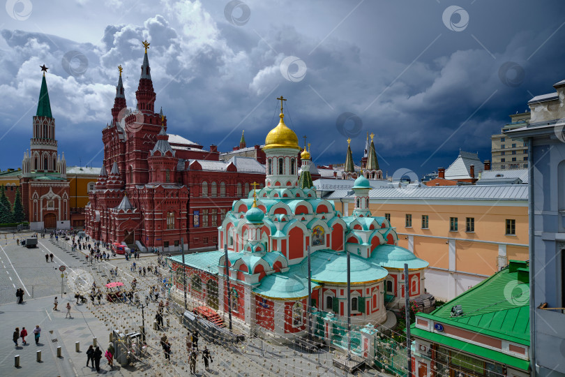 Скачать Москва. Исторический музей, Никольская башня Кремля, Казанский собор на Красной площади и надвигающийся дождь. фотосток Ozero