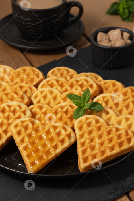 Скачать Вкусные вафли в форме сердечек подаются с кофе и сахаром на деревянном столе фотосток Ozero