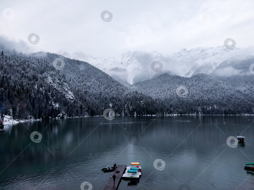 Скачать Озеро Рица. Горное озеро. Снежный лес зимой в горах у озера фотосток Ozero