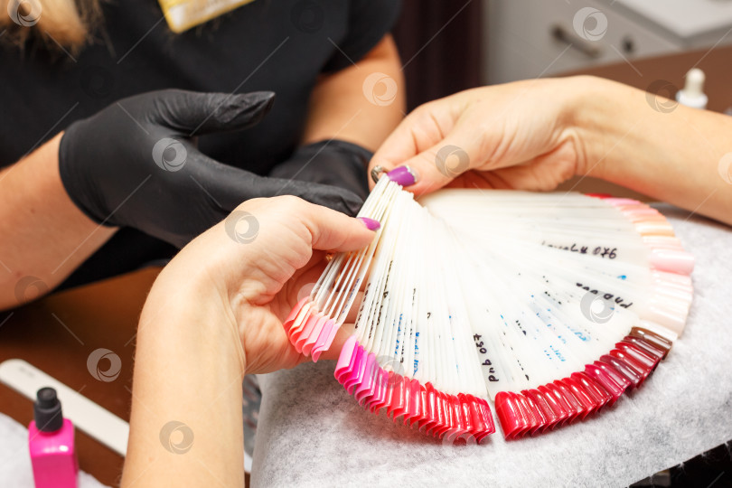 Скачать клиент в салоне маникюра выбирает цвет лака для ногтей фотосток Ozero