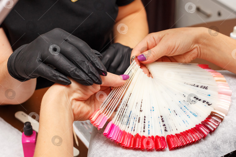 Скачать клиент в салоне маникюра выбирает цвет лака для ногтей фотосток Ozero