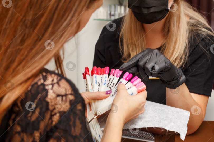 Скачать клиент в салоне маникюра выбирает цвет лака для ногтей фотосток Ozero