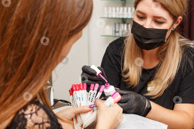 Скачать клиент в салоне маникюра выбирает цвет лака для ногтей фотосток Ozero